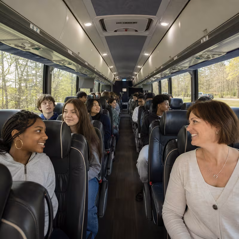 Group boarding a white charter bus for School Transportation transportation in Jersey City